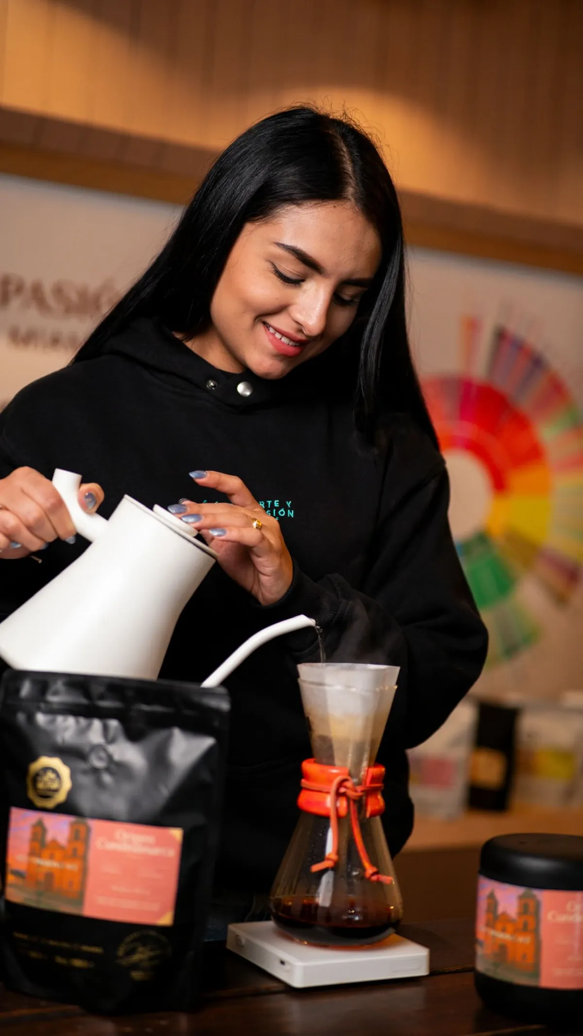 Barista vertiendo agua caliente sobre un café de origen junto a la rueda de sabores